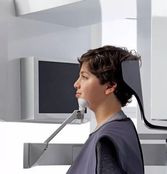 boy seated at i-CAT 3D CBCT Scanner Modern orthodontic technology: Boy getting a detailed 3D scan for precise treatment planning