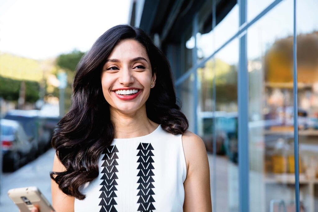 confident business woman smiling wearing Invisalign clear aligners on city street Confident businesswoman smiling while wearing Invisalign clear aligners on a city street.